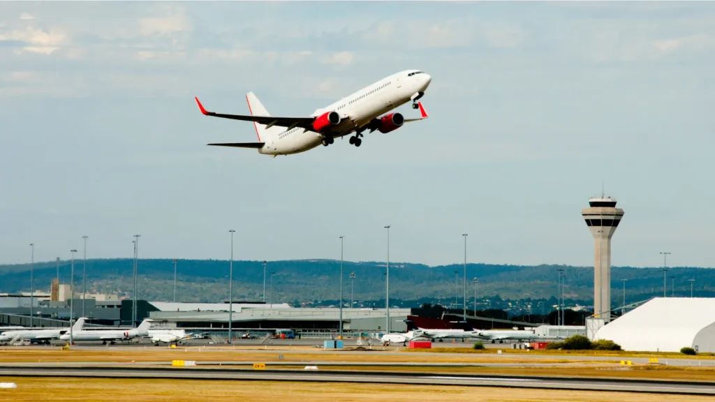 Avion au décollage devant la tour de contrôle et les terminaux d’un aéroport près d’Antibes, Côte d’Azur.